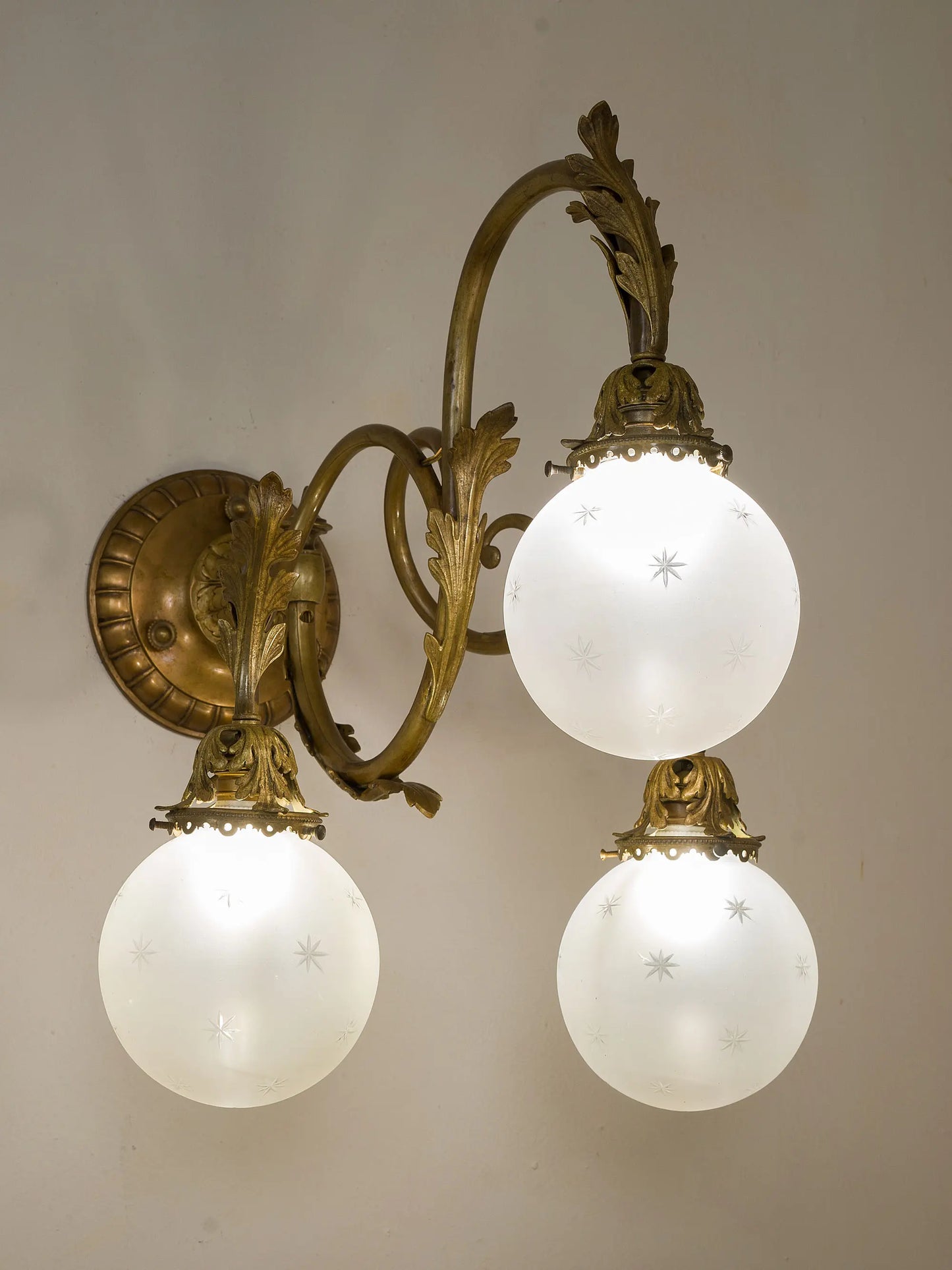 Lampada da parete accesa, con giochi di luce diffusi dai vetri intagliati. | Lo Stile Italiano