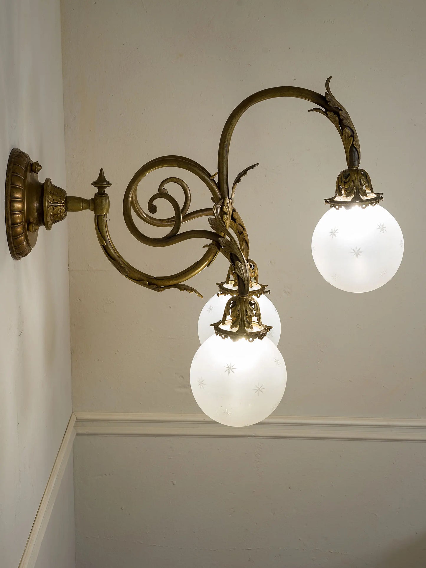 Lampada a parete Liberty a tre luci con decori fogliati e struttura in bronzo | Lo Stile Italiano