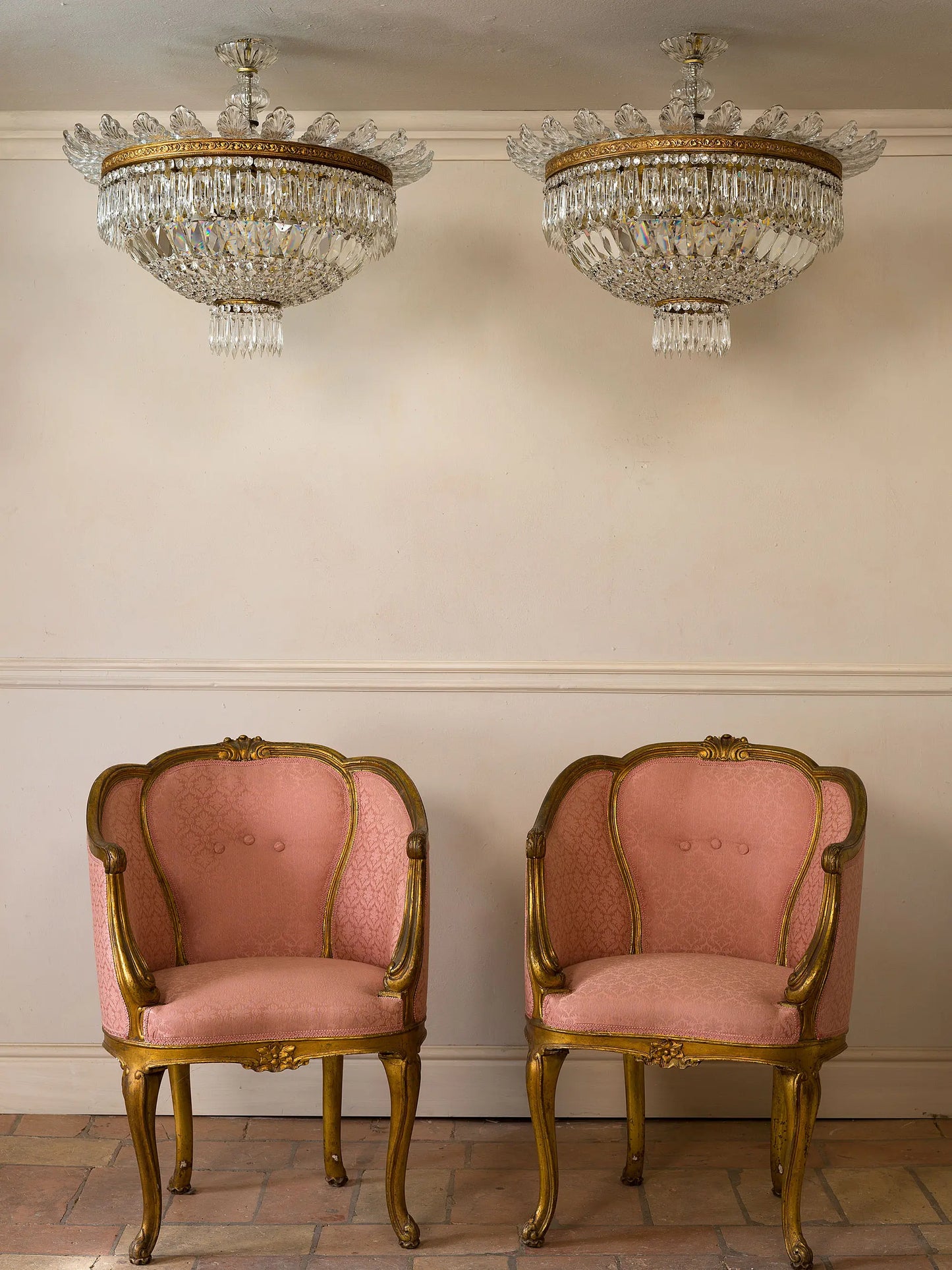 Coppia di lampadari vintage di lusso in ottone e cristallo, fotografati insieme a una coppia di poltroncine antiche in stile Napoleone III | Lo Stile Italiano | Lo Stile Italiano