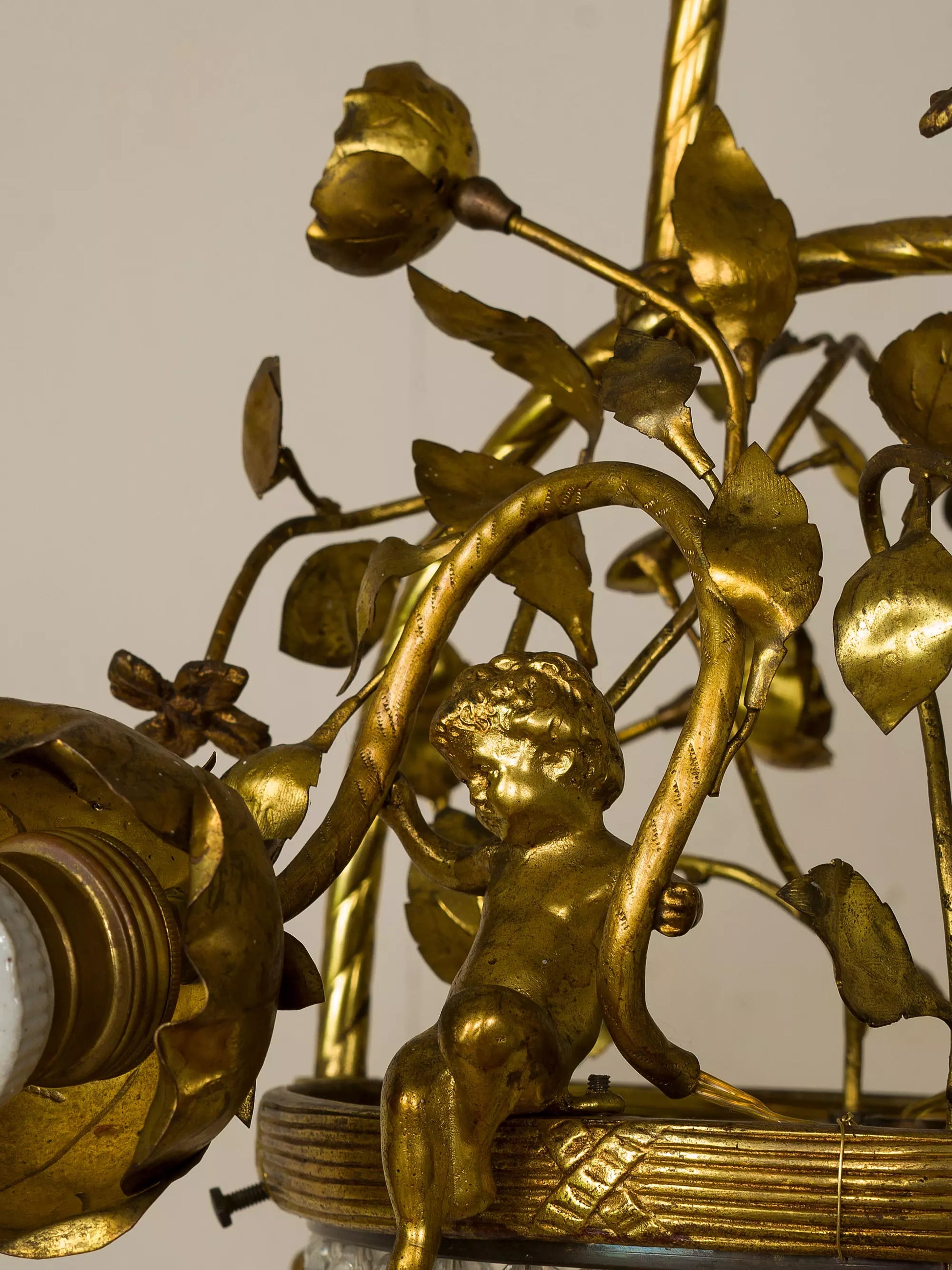 Dettaglio delle foglie dorate che avvolgono la struttura centrale del lampadario | Lo Stile Italiano