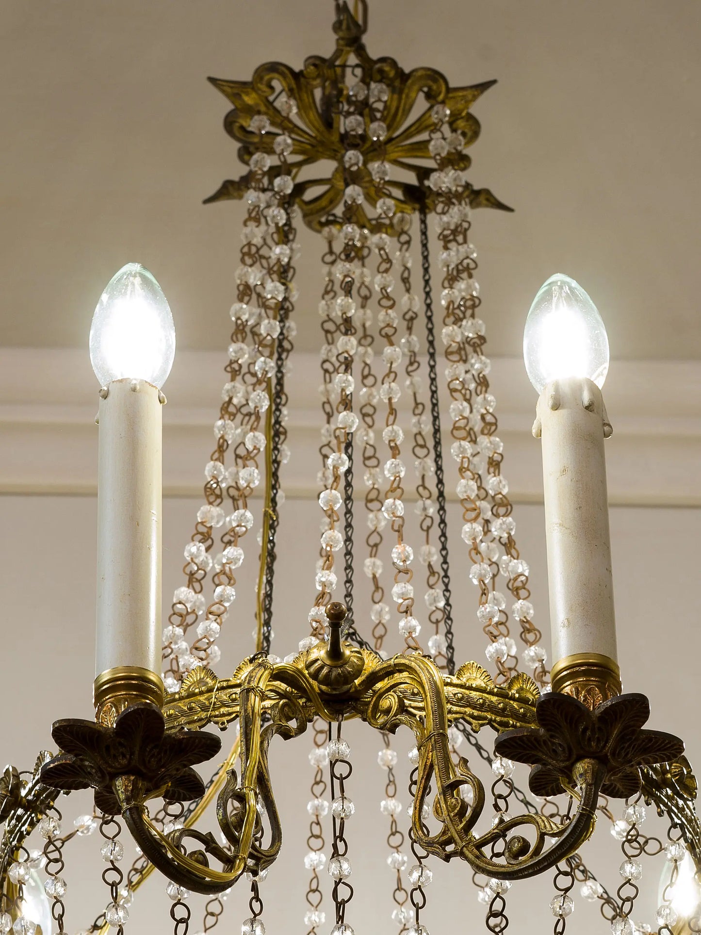 Bracci in bronzo cesellato e dorato sorreggono le candele di legno | Lo Stile Italiano