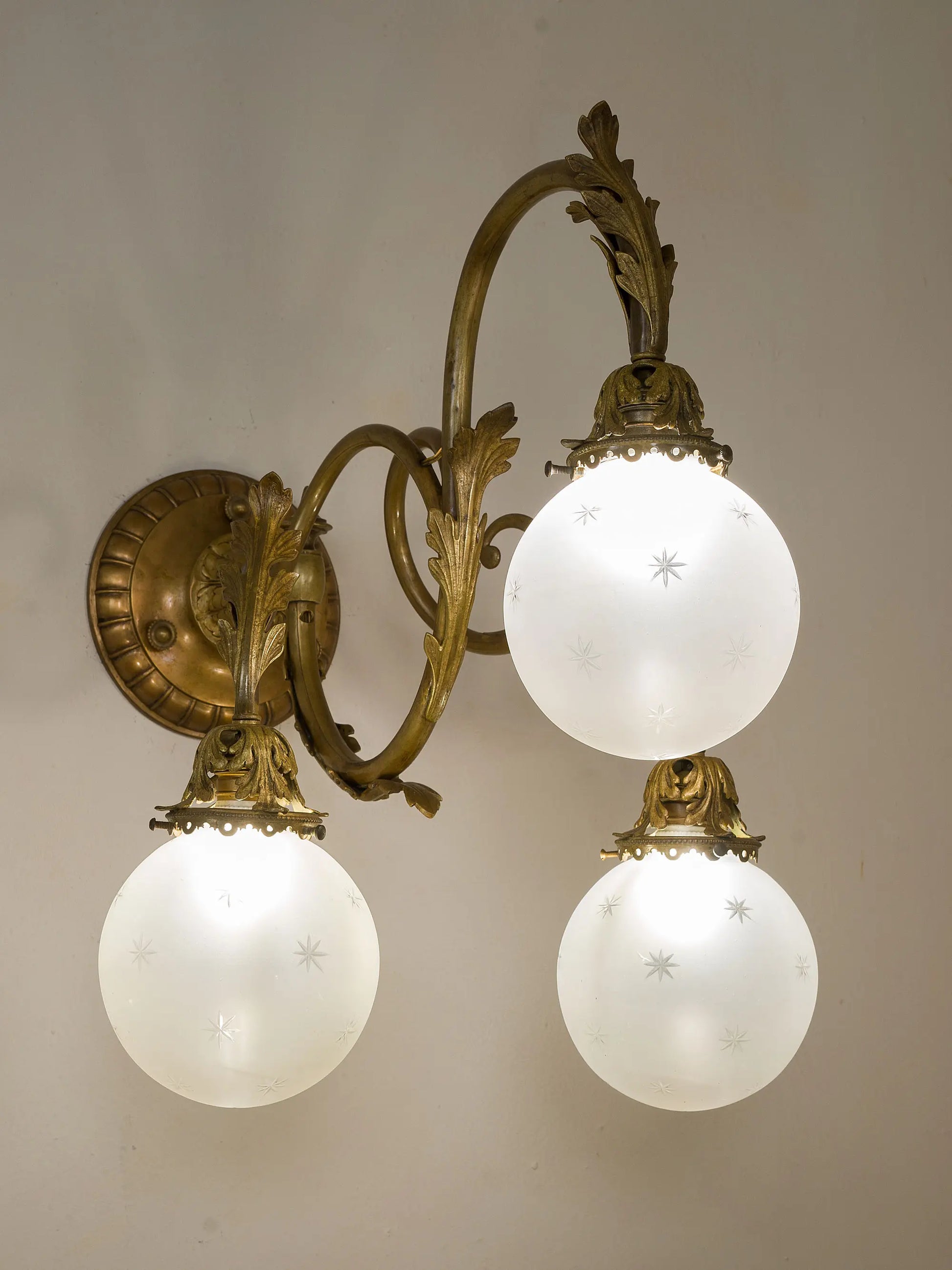 Lampada da parete accesa, con giochi di luce diffusi dai vetri intagliati. | Lo Stile Italiano