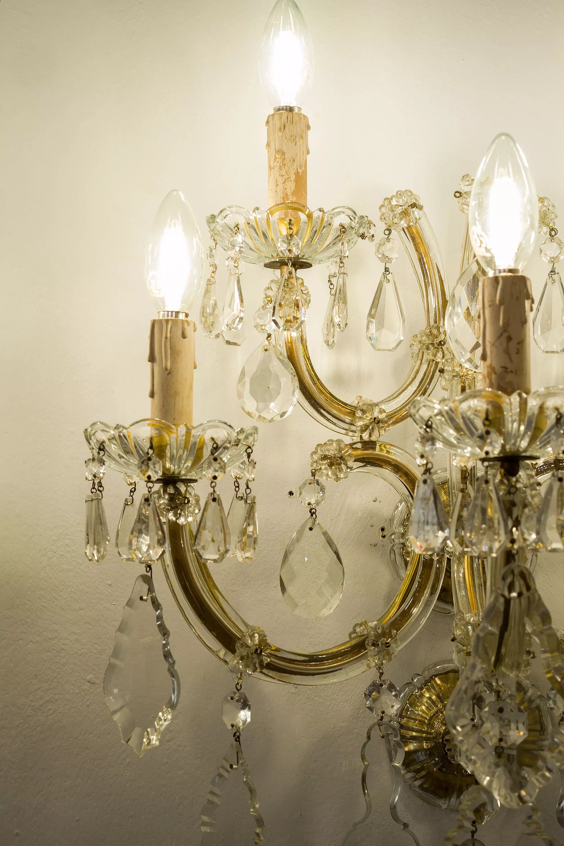 Lampade a muro in cristallo dalle linee sinuose, impreziosite da placche e gocce scintillanti | Lo Stile Italiano.