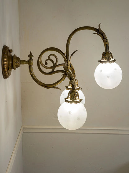 Lampada a parete Liberty a tre luci con decori fogliati e struttura in bronzo | Lo Stile Italiano