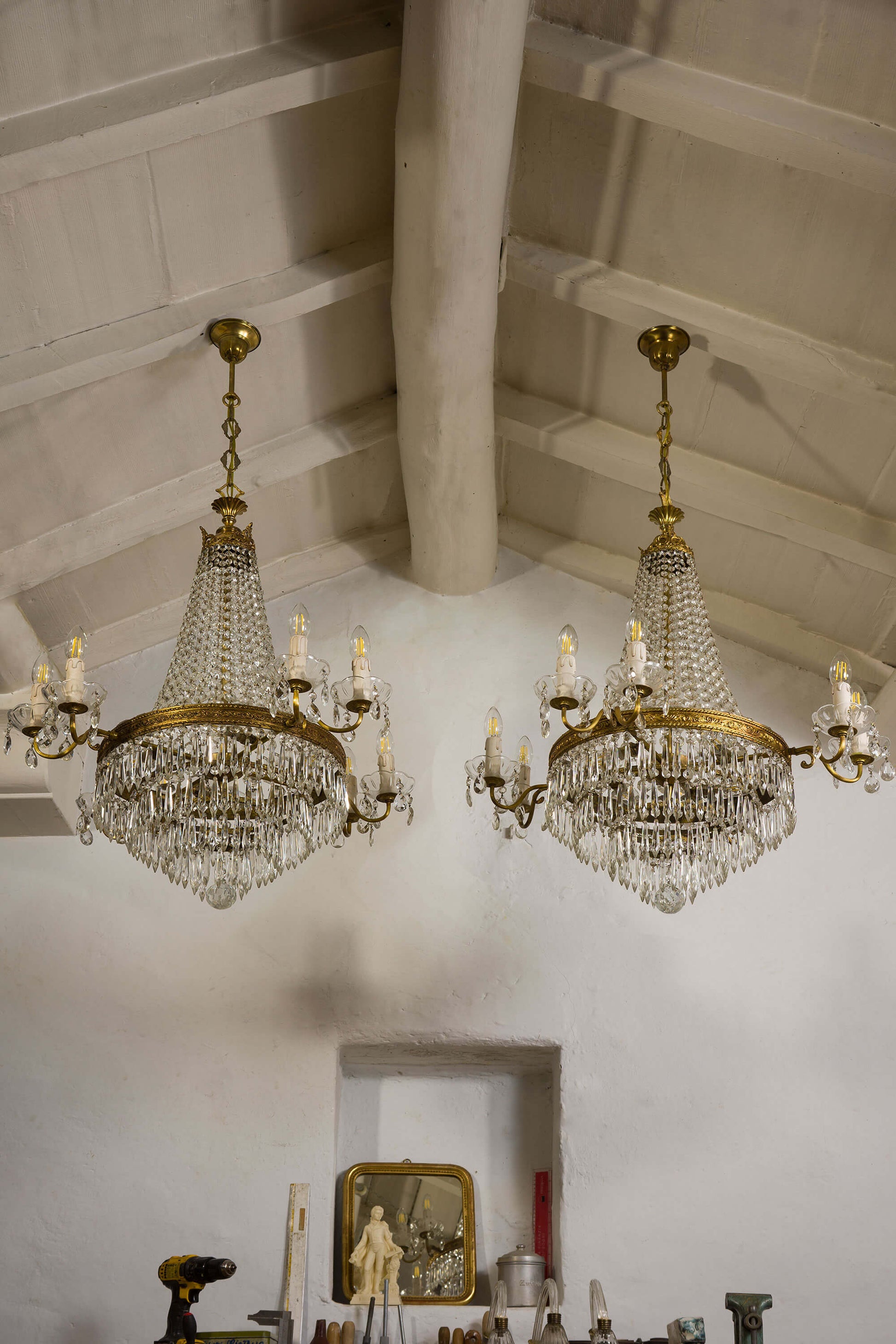 Coppia di lampadari vintage realizzati in ottone cesellato e arricchiti da file di catene di ottagoni in vetro e gocce di cristallo.| Lo Stile Italiano