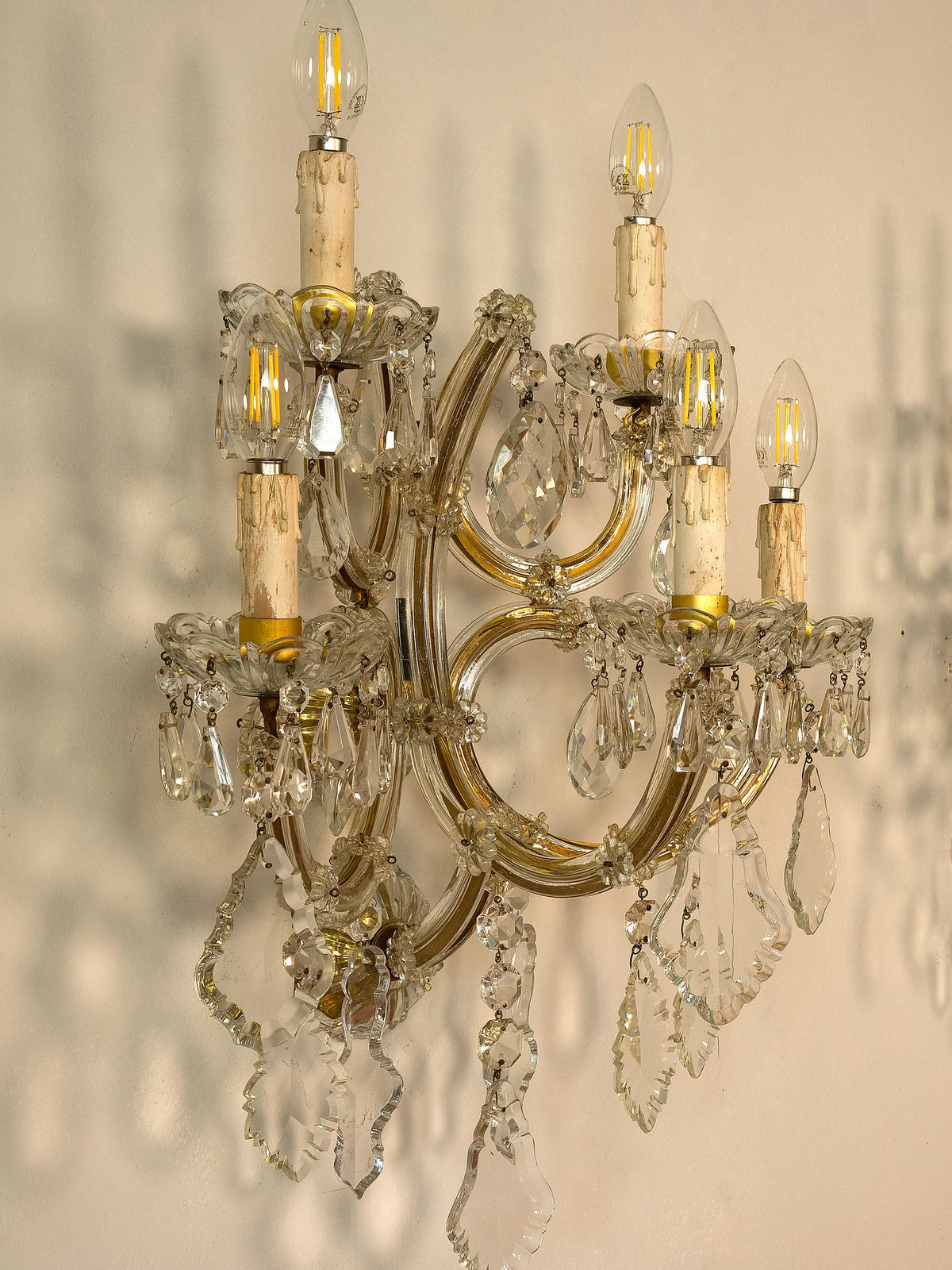 Applique antica restaurata con struttura dorata e pendenti in cristallo molato | Lo Stile Italiano