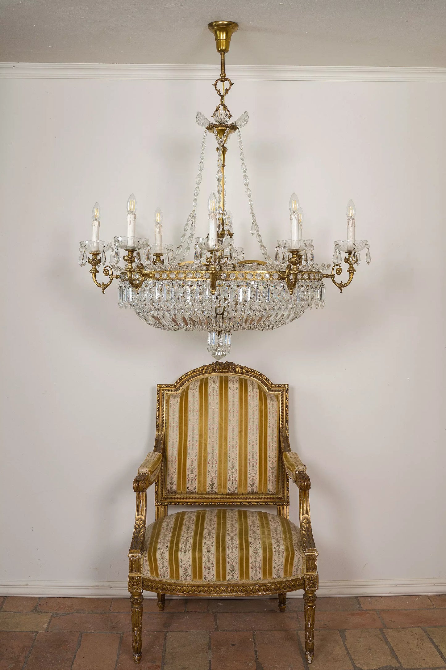 Grande Lampadario di cristallo in Stile Impero, fotografato insieme ad una poltrona antica Luigi XVI| Lo Stile Italiano