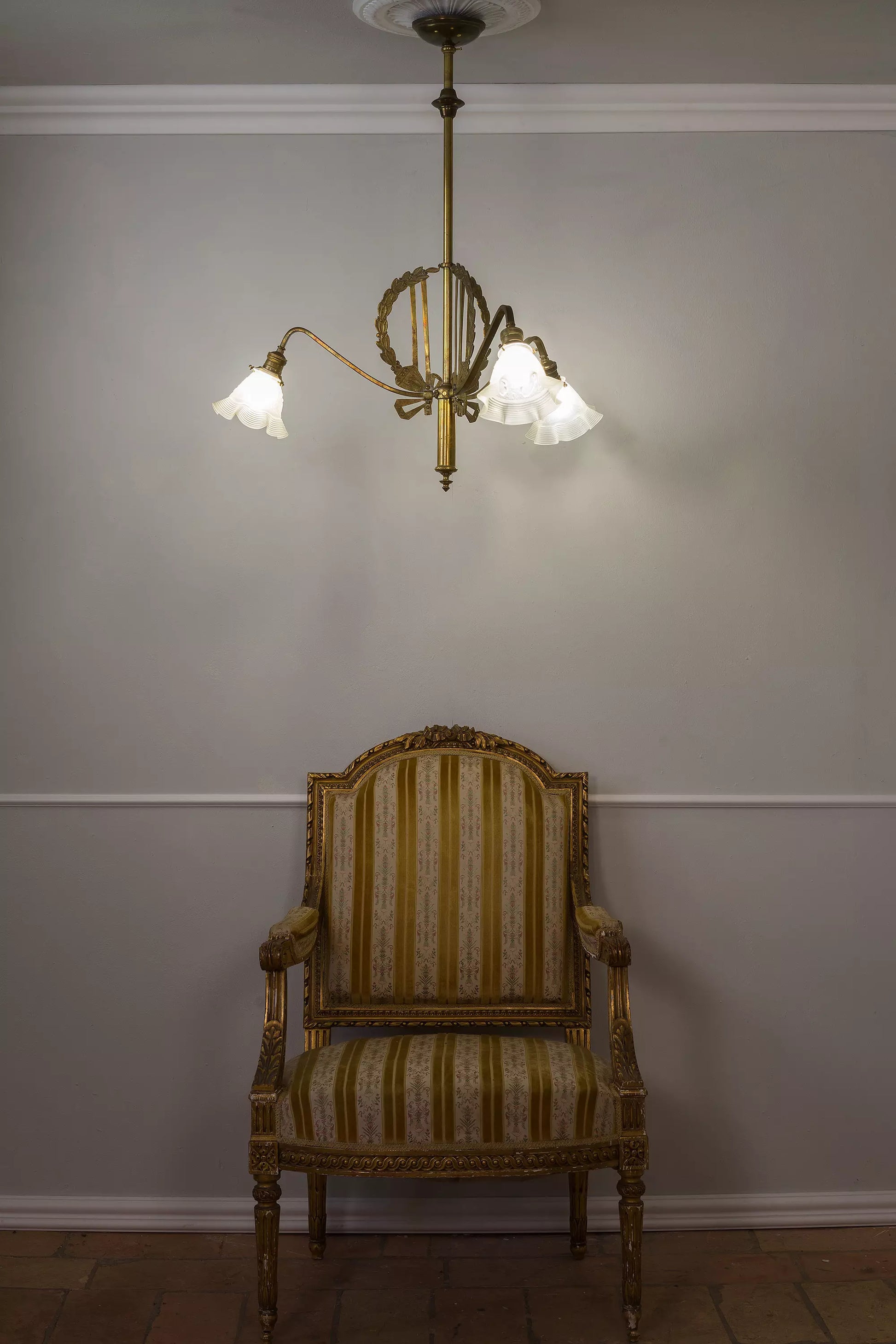 Lampadario antico Art Nouveau a trte luci, fotografato assieme ad una poltrona Luigi XVI.| Lo Stile Italiano