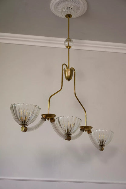 Un lampadario retrò che richiama lo stile vintage degli anni passati, con una combinazione di forme curve e geometriche.