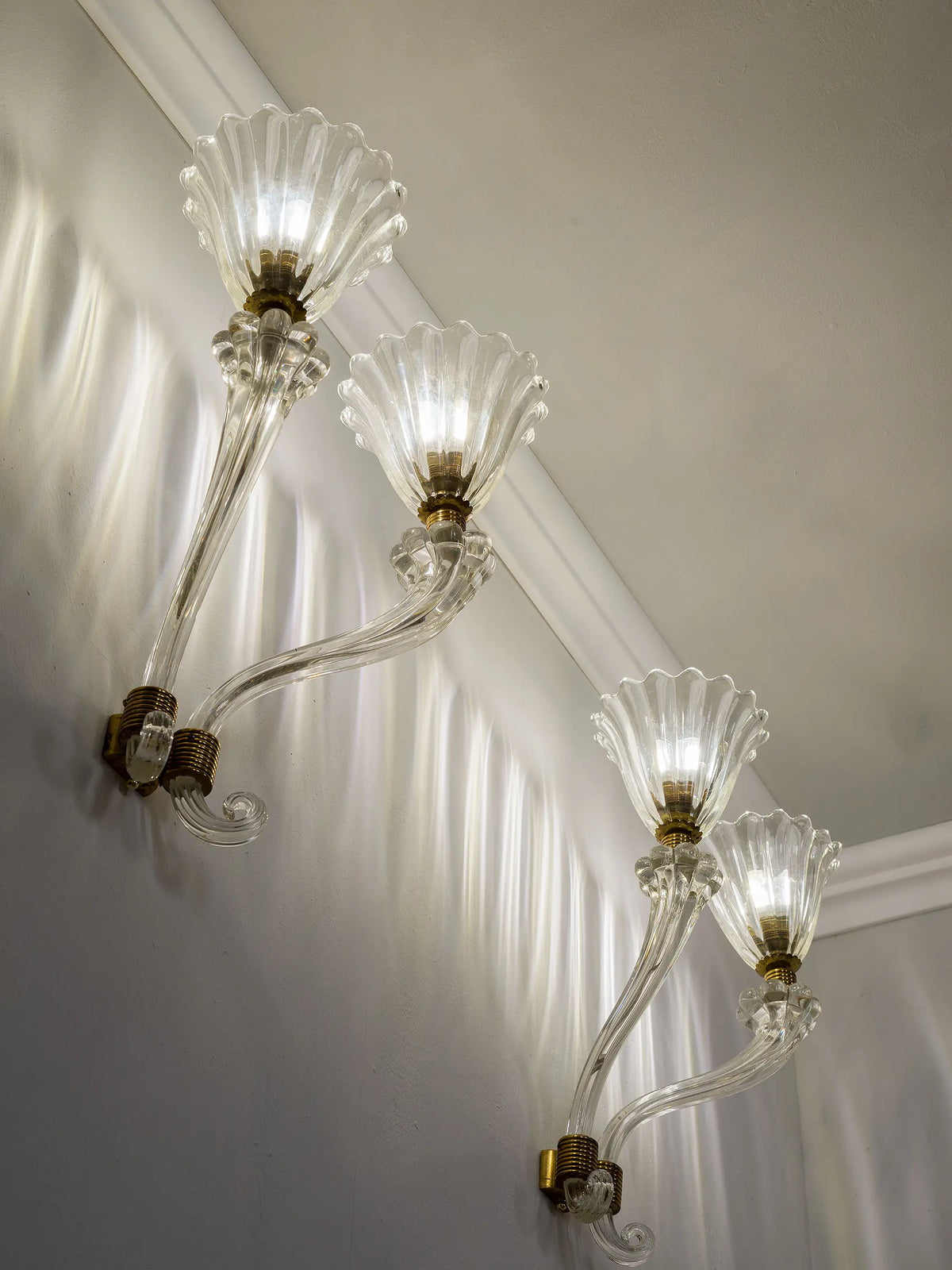 Brass supports and glass curl of a Murano wall light | Lo Stile Italiano