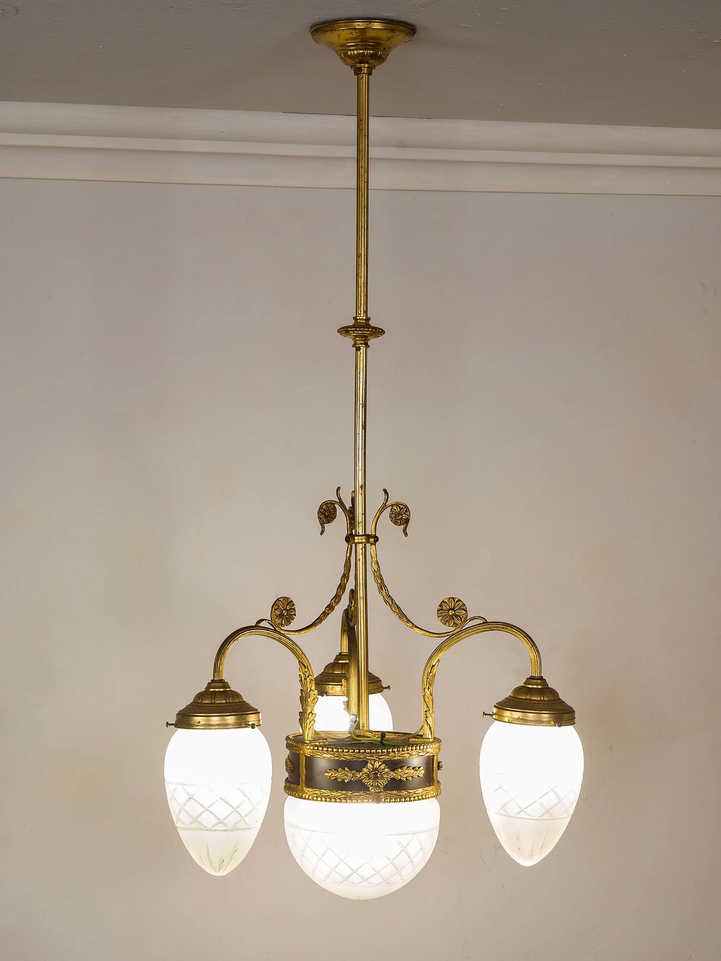 Lampadario dei primi anni del ’900 acceso, con luce morbida diffusa dai vetri satinati.| Lo Stile Italiano