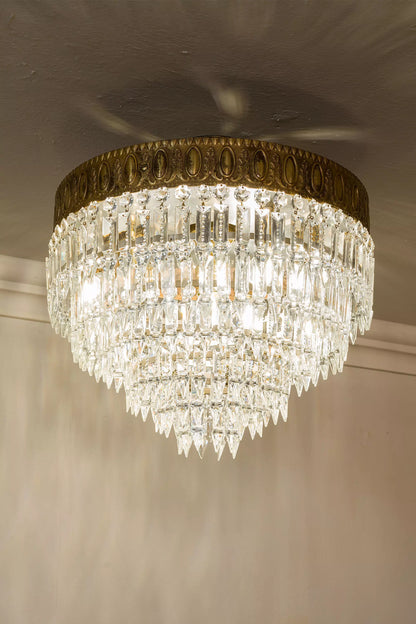Riflessi luminosi sui cristalli molati di una plafoniera restaurata. | Lo Stile Italiano