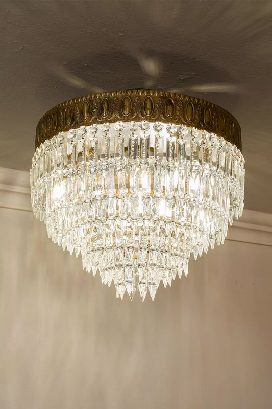 Riflessi luminosi sui cristalli molati di una plafoniera restaurata. | Lo Stile Italiano