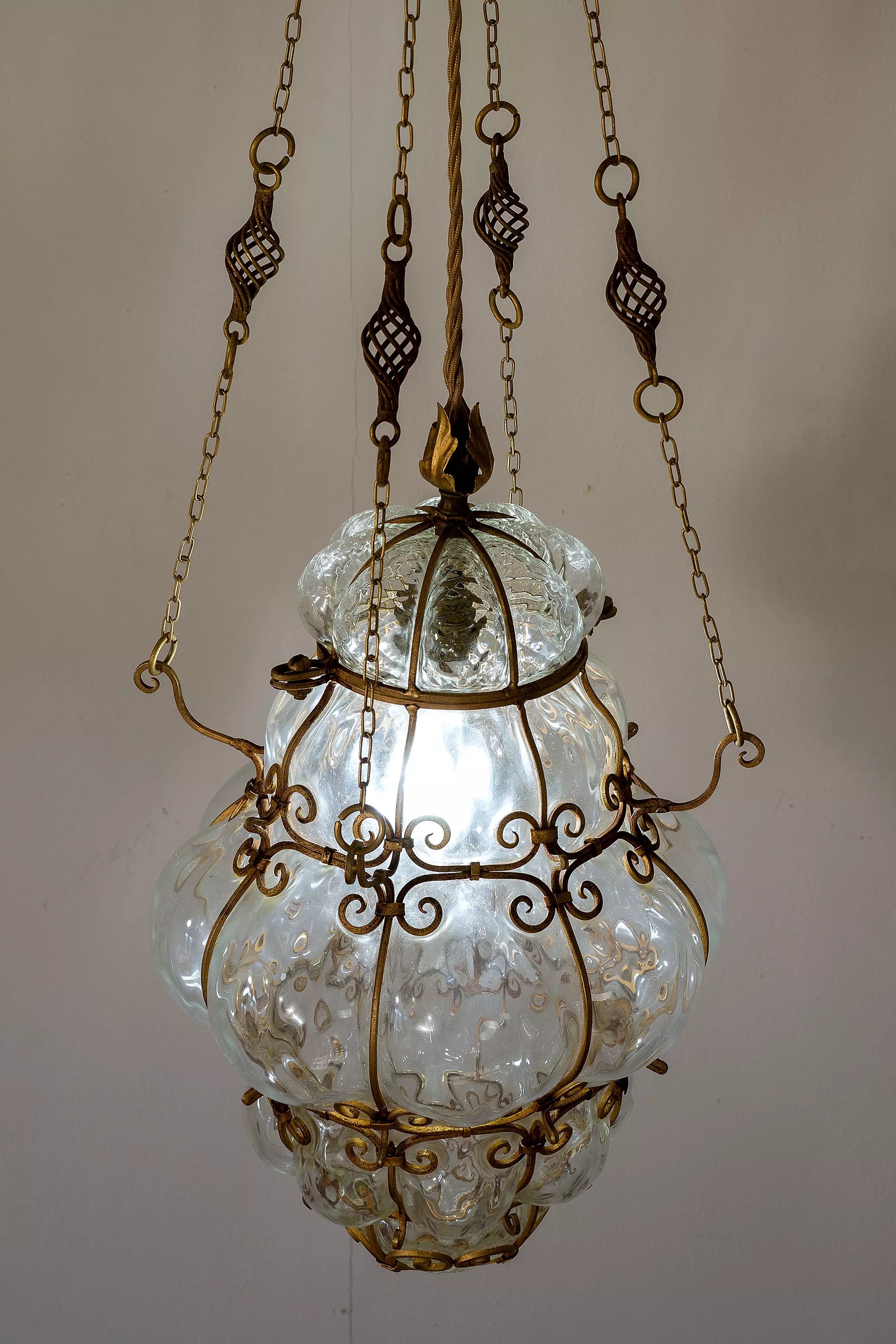 Lampadario antico di vetro sorretto da 4 catene in ferro dorato.| Lo Stile Italiano