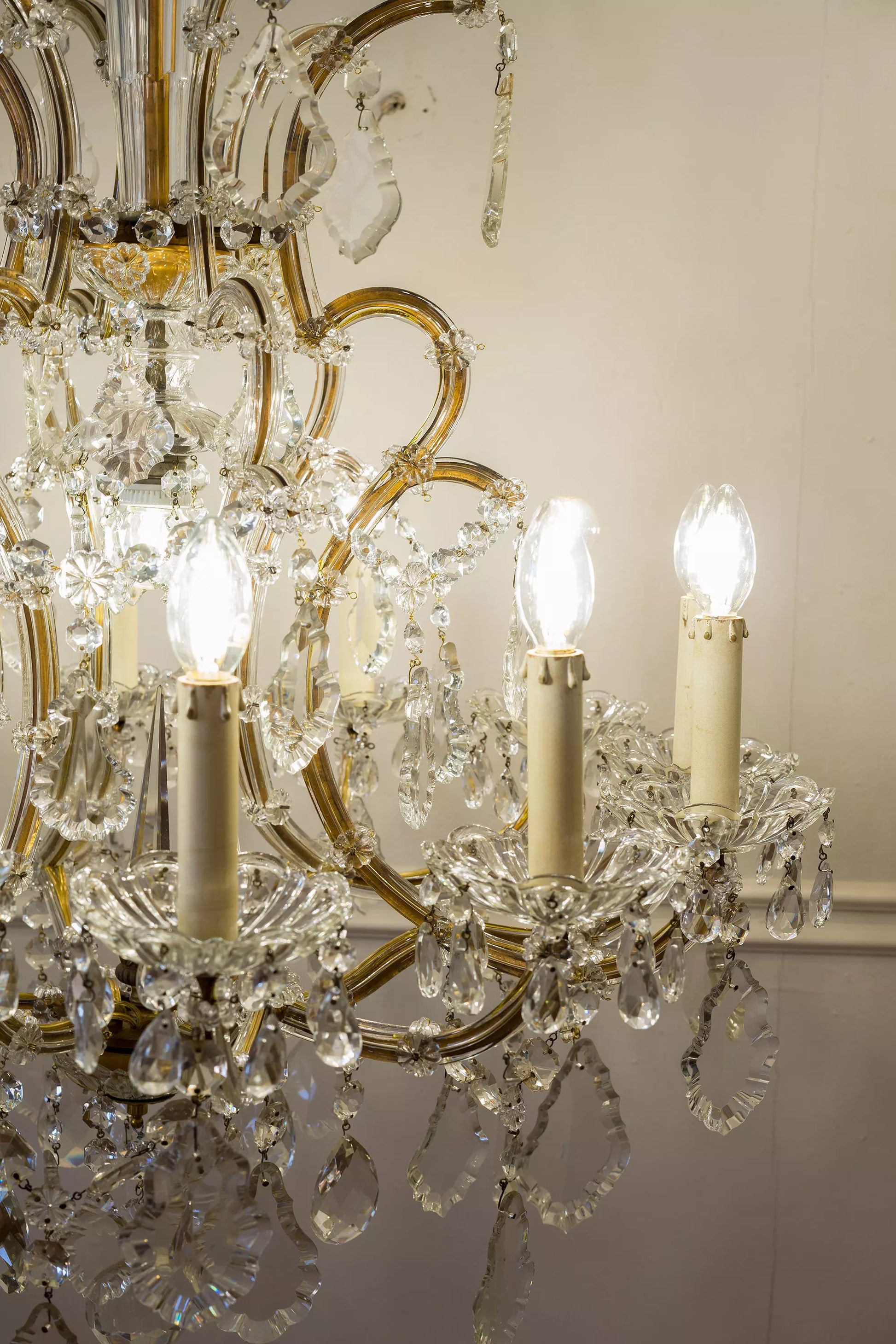 Bracci e candele del lampadario acceso. | Lo Stile Italiano