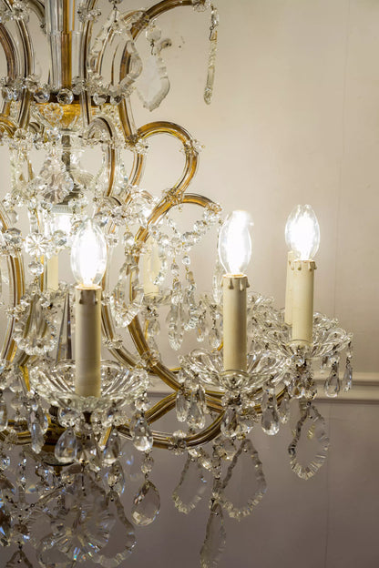 Bracci e candele del lampadario acceso. | Lo Stile Italiano