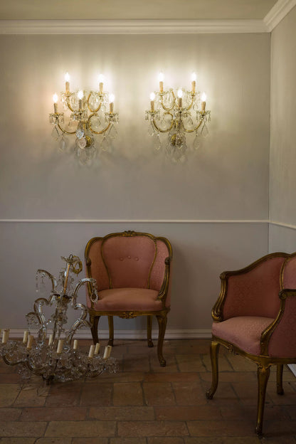 Splendenti applique d'epoca in cristallo, con curve armoniose e cristalli pendenti che riflettono la luce | Lo Stile Italiano.