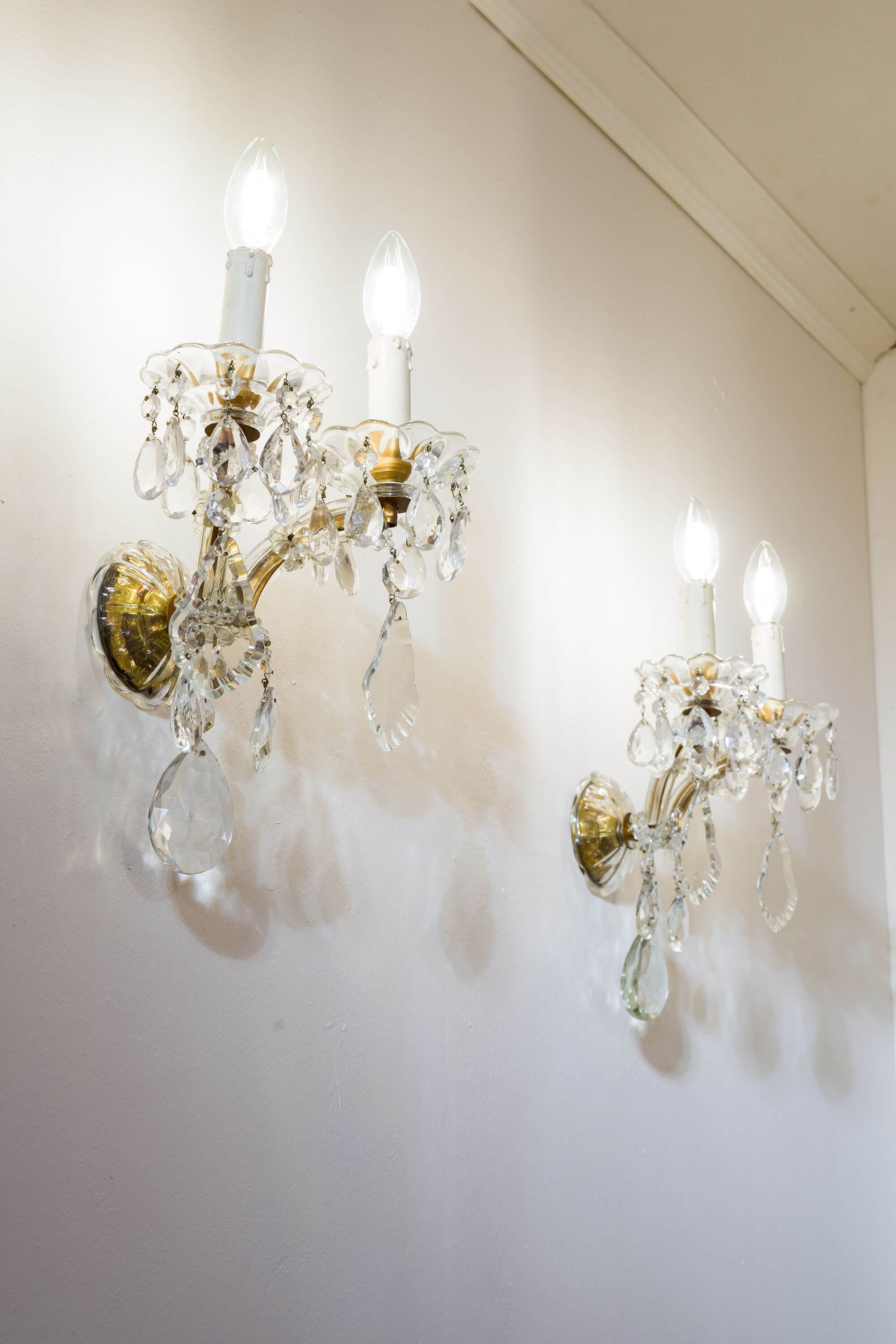Antiche lampade a muro con gemme ottagonali e delicate placche di cristallo pendenti.|Lo Stile Italiano