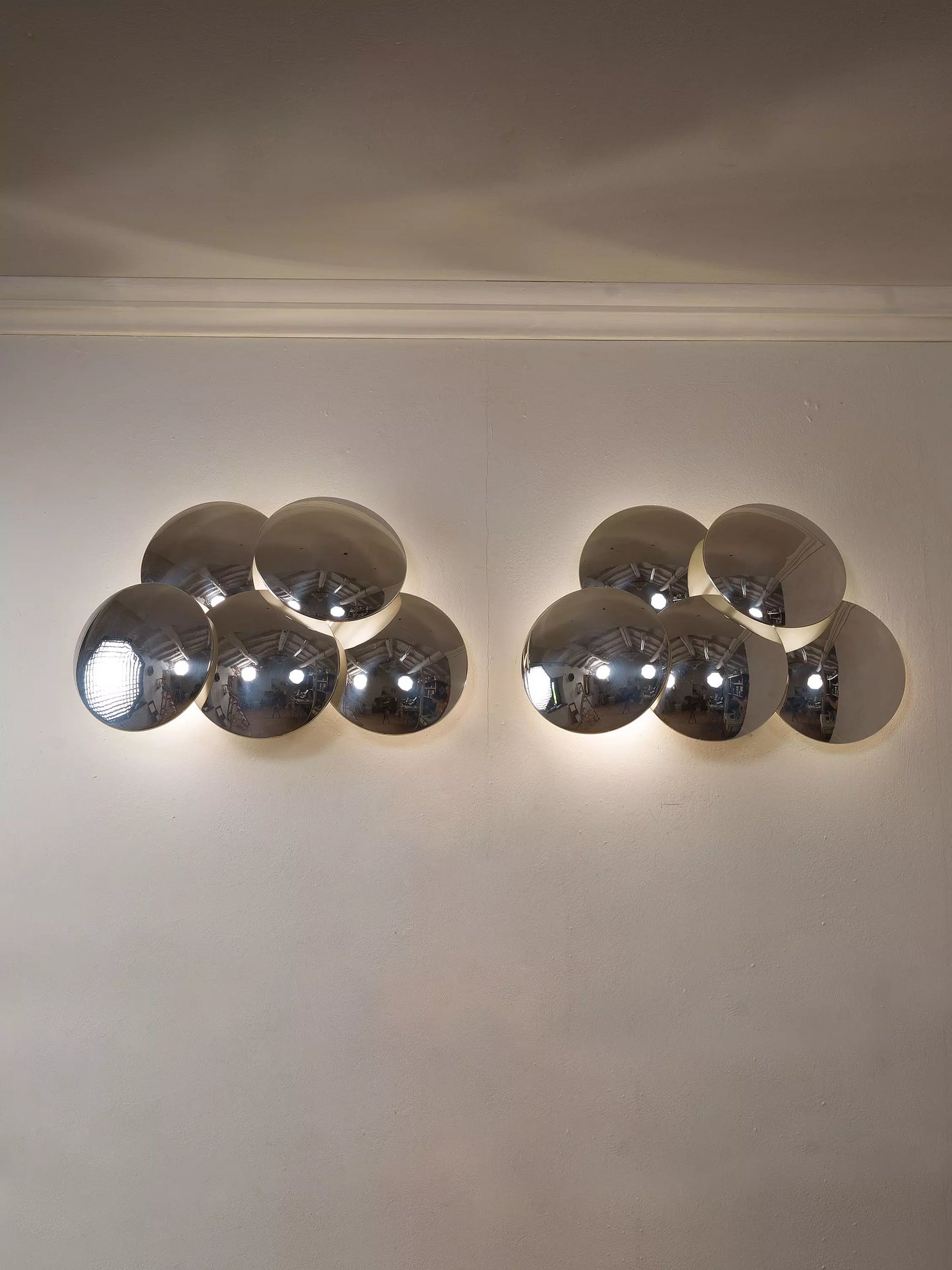 Coppia di applique Reggiani anni ’70 in metallo cromato. Luce riflessa e giochi visivi unici. | Lo Stile Italiano