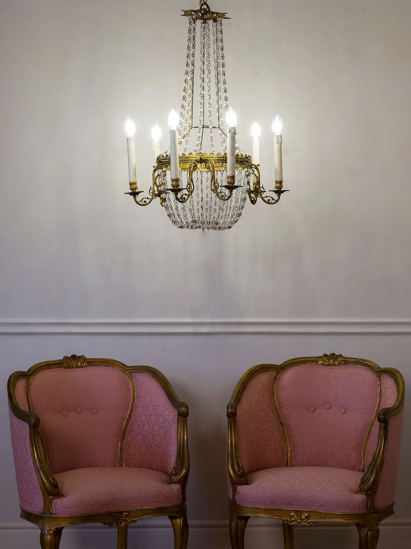 Lampadario antico con gocce di cristallo fotografato insieme a due poltroncine antiche Napoleone III | Lo Stile Italiano