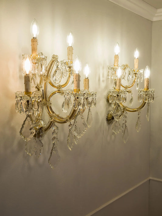 Pair of antique crystal wall sconces illuminated in a classic setting | Lo Stile Italiano
