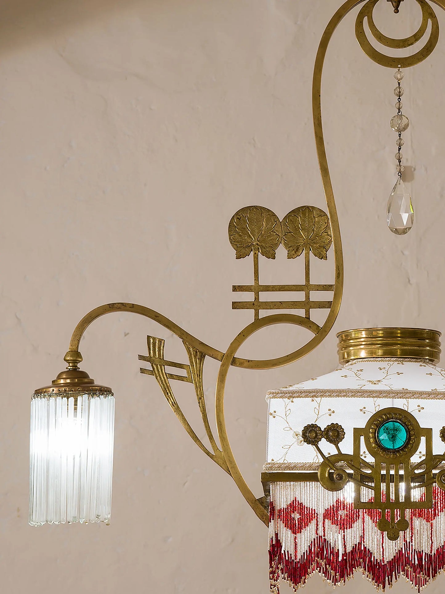 Elegante lampadario in ottone e vetro con fregi nella parte bassa composti da piccole palline colorate che creano un motivo geometrico - Lo Stile Italiano