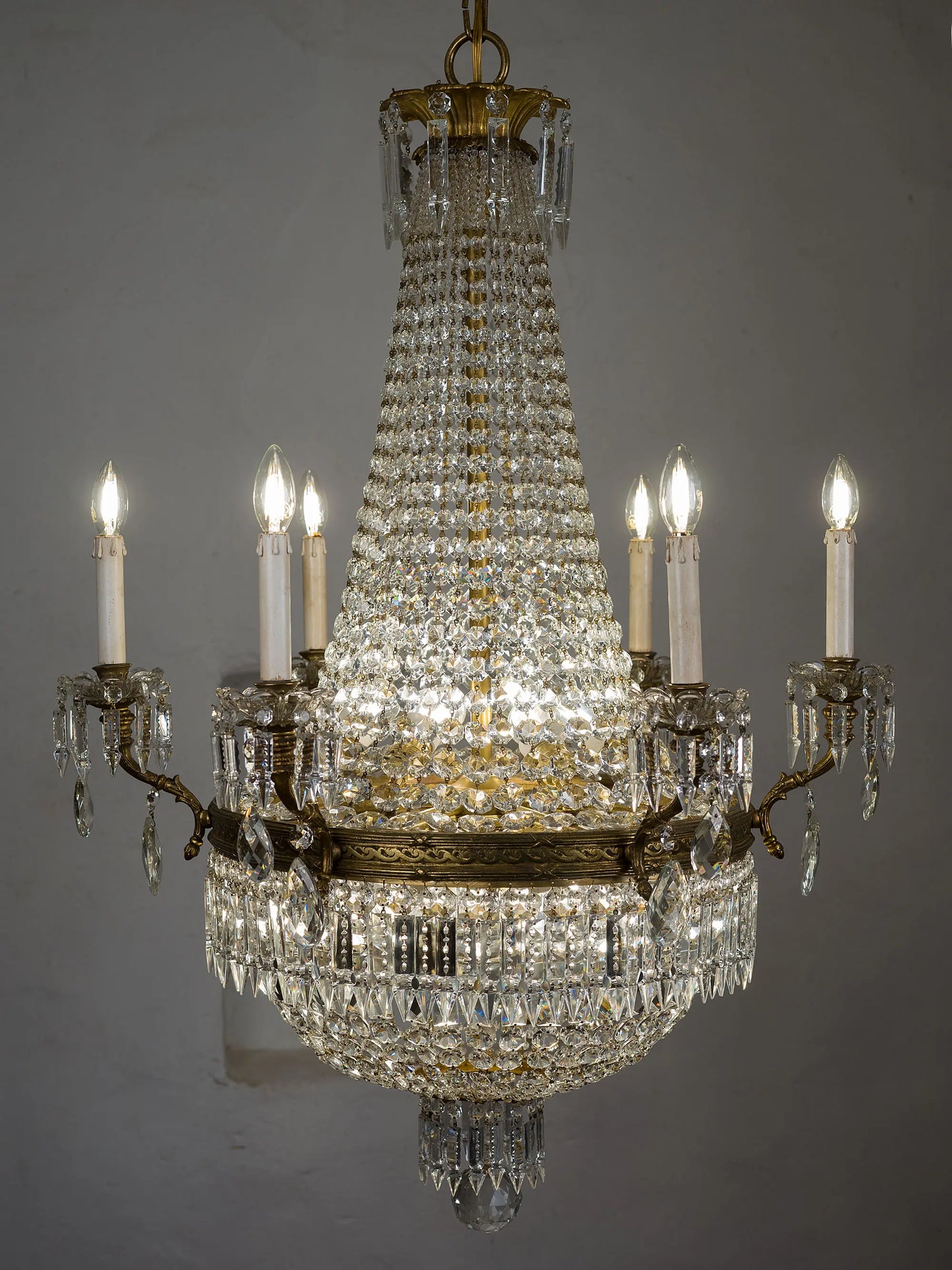 Lampadario di lusso molto luminoso dei primi del '900 realizzato in bronzo e cristallo illuminato da 18 luci, sei candele esterne e 12 luci interne