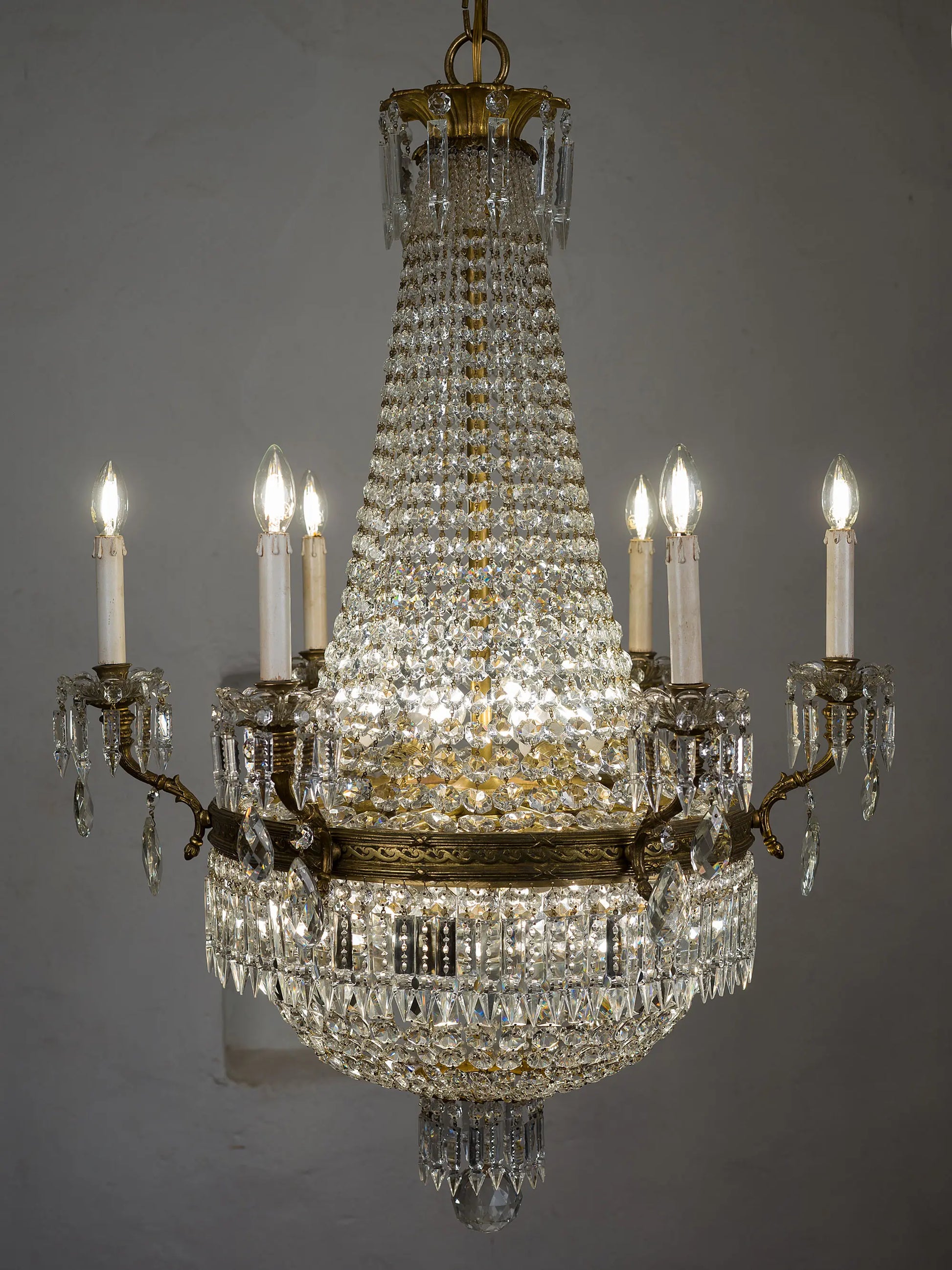 Lampadario di lusso molto luminoso dei primi del '900 realizzato in bronzo e cristallo illuminato da 18 luci, sei candele esterne e 12 luci interne