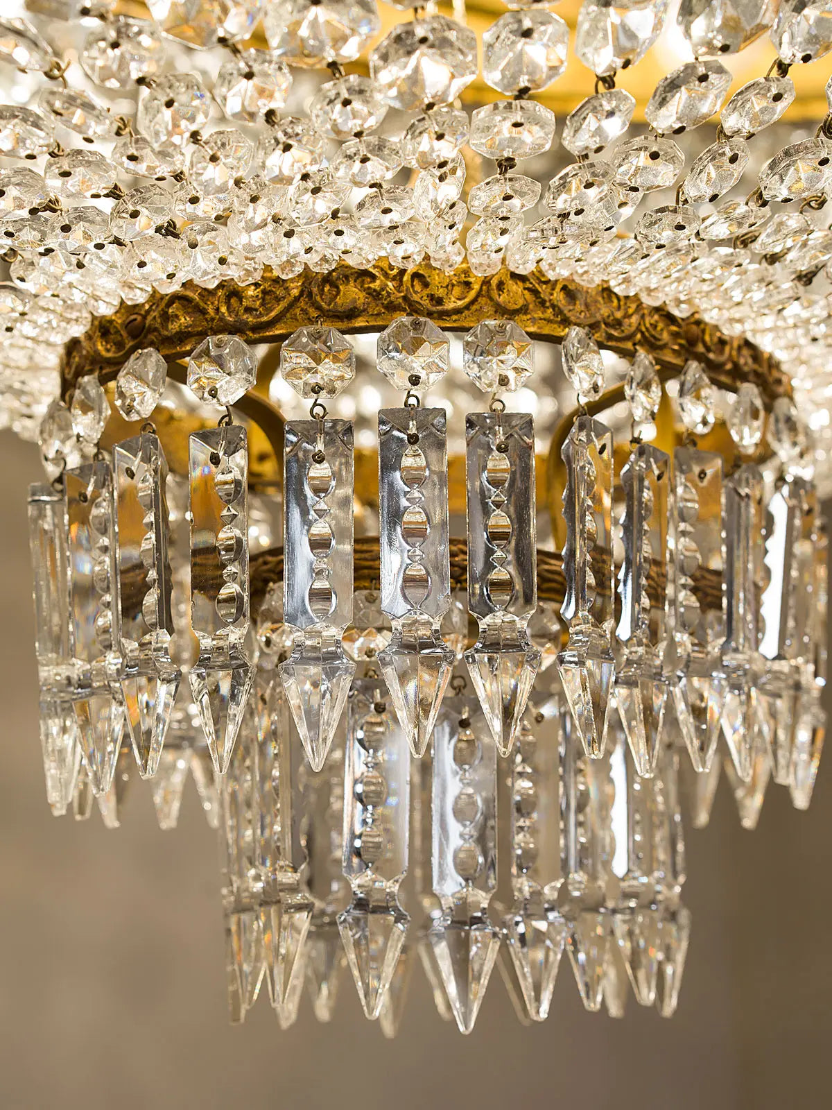 Gocce di cristallo pendenti a forma di freccia posizionati nella parte in basso al lampadario. - Lo Stile Italiano