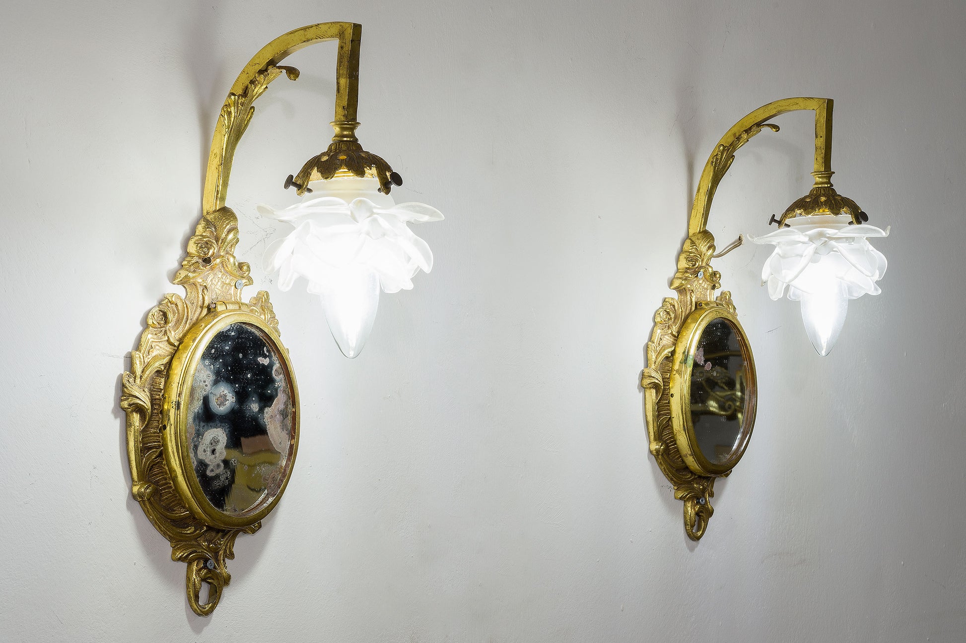 Coppia di applique Stile Luigi XVI in ottone con specchio centrale e paralumi in vetro opalino.-Lo Stile Italiano