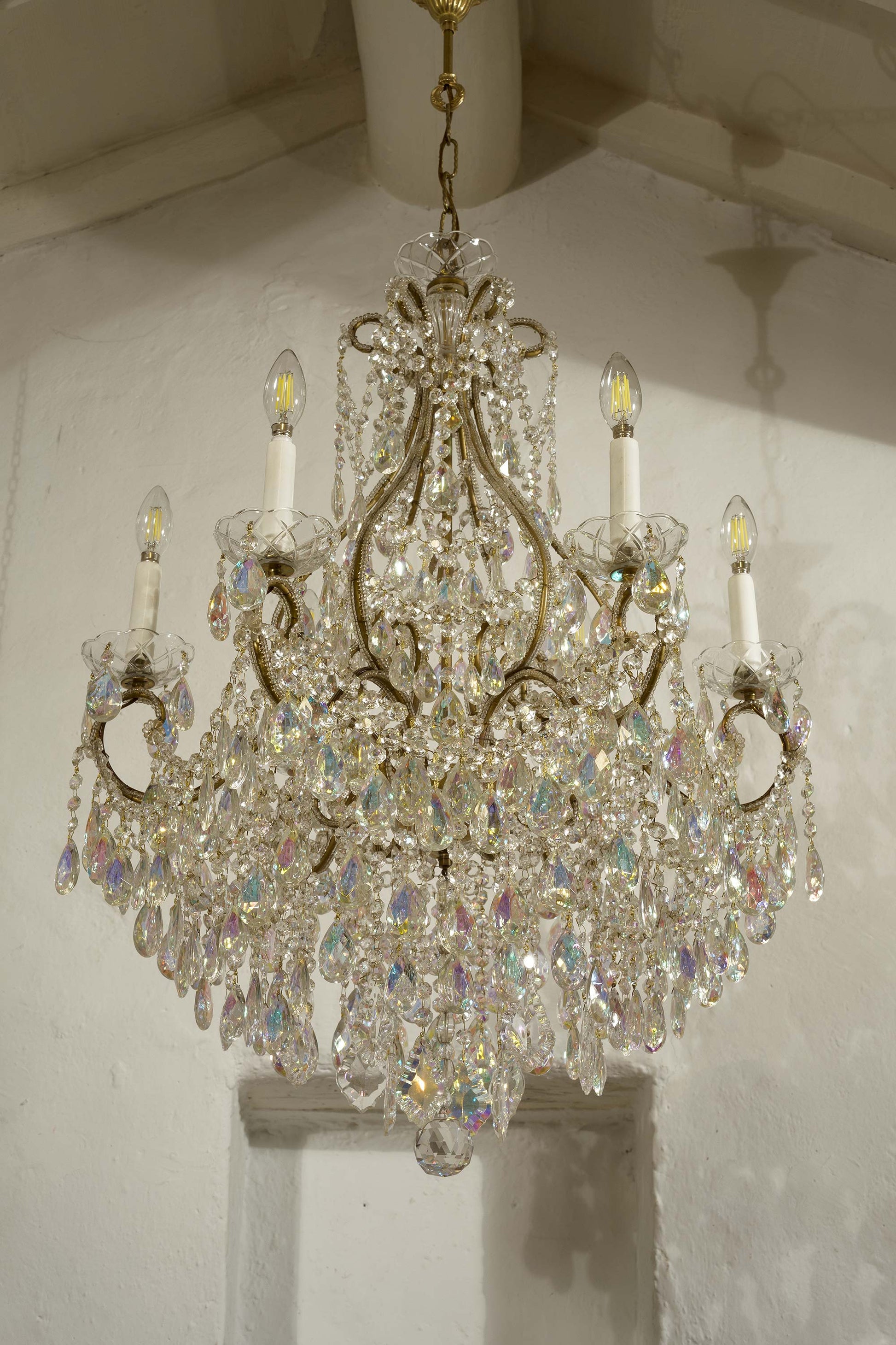 Lampadario stile Maria Teresa con 6 candele E12. Il lampadario è arricchito da catene ottagonali che sostengono una moltitudine di gocce pendenti "Aurora boreale" che hanno un colore particolare-Lo Stile Italiano