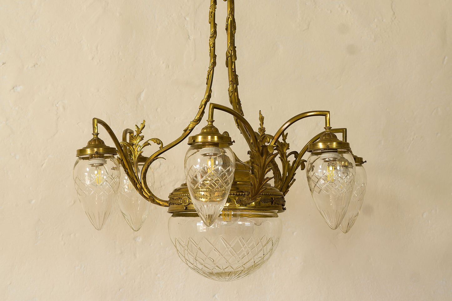 Lampadario Liverty in ottone cesellato e globi di cristallo.-Lo Stile Italiano