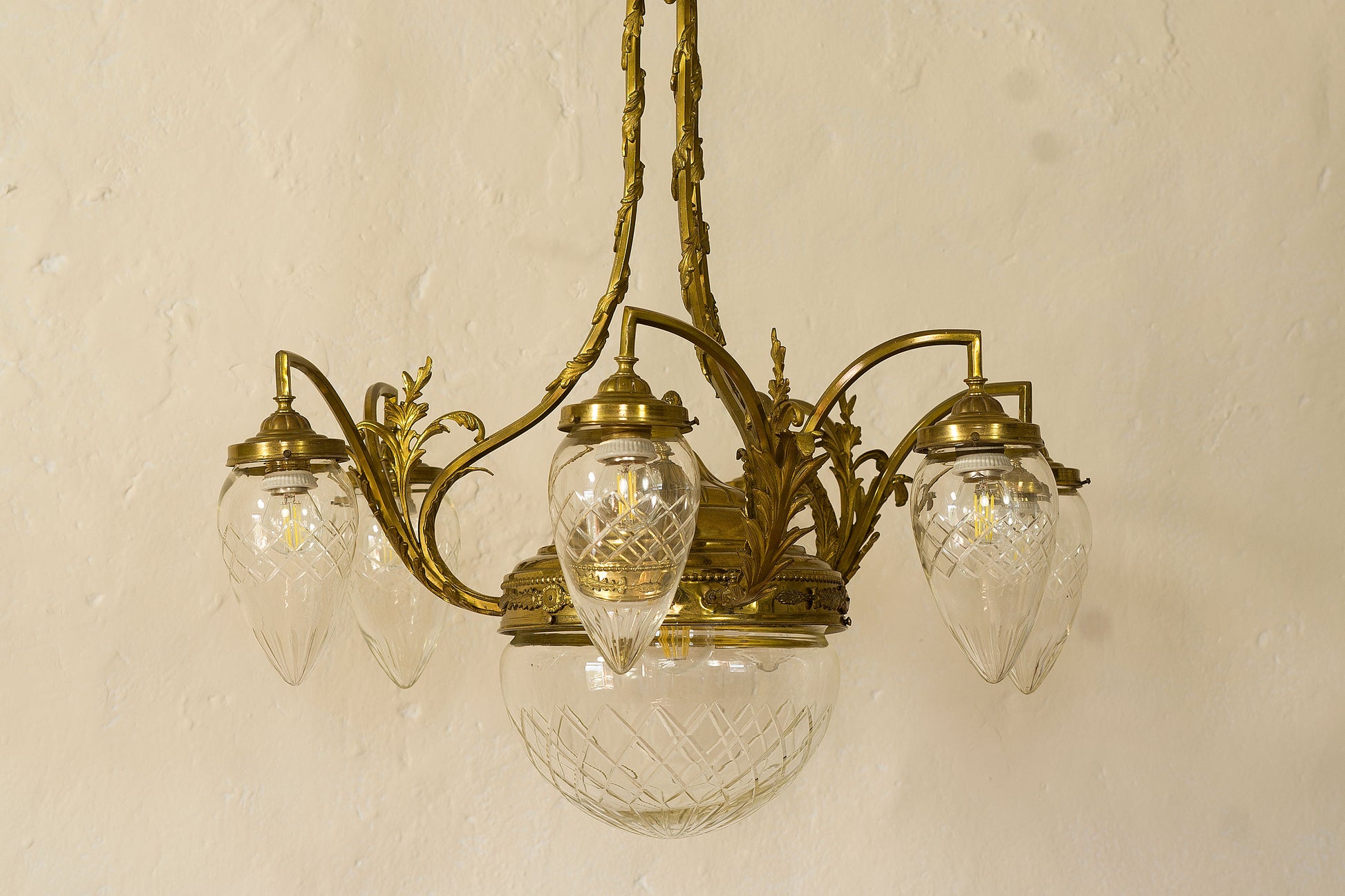 Lampadario Liverty in ottone cesellato e globi di cristallo.-Lo Stile Italiano