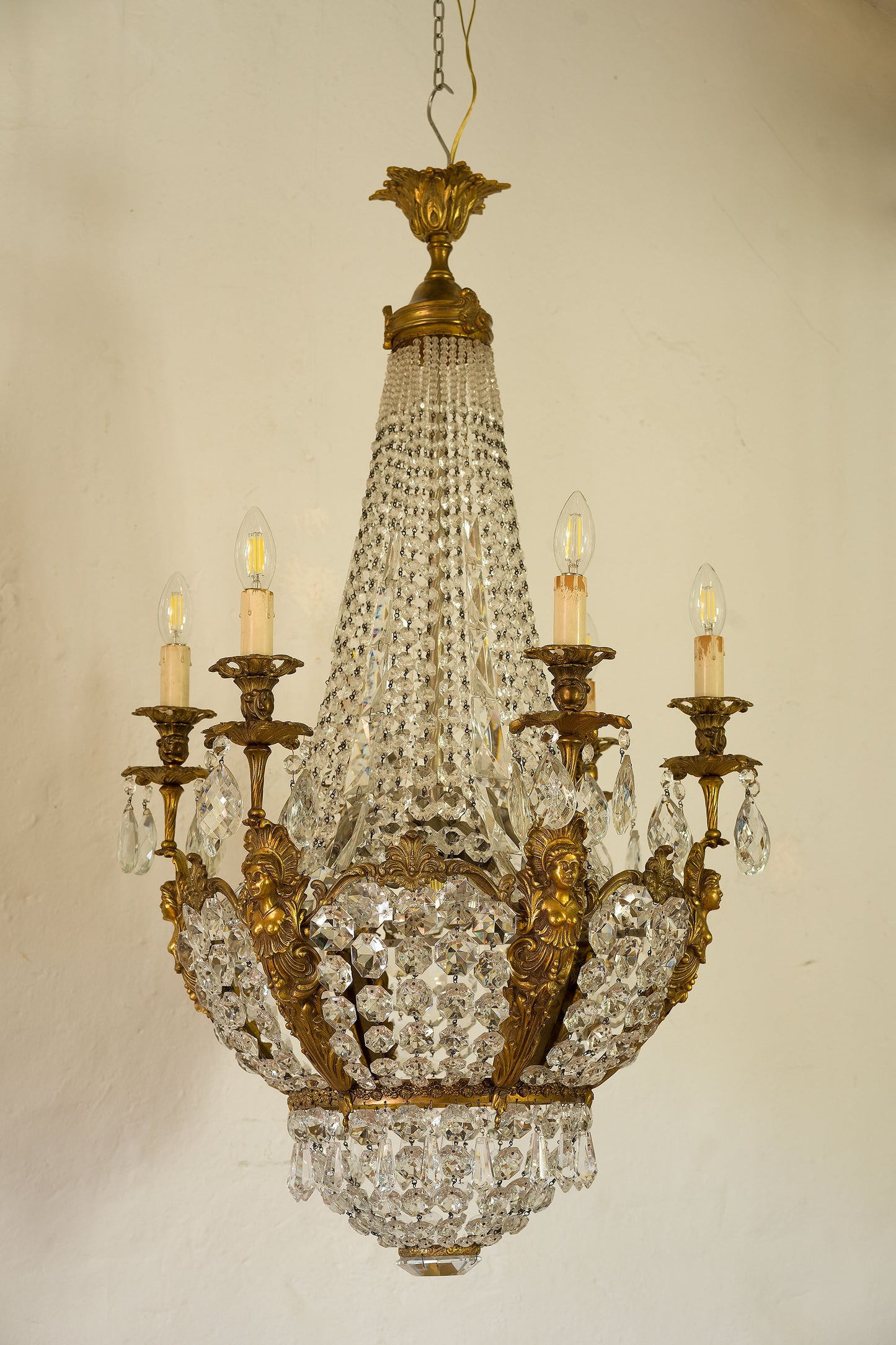 Lampadario Stile Impero con gocce di cristallo pendenti, la struttura bronzo dorato è abbellita da 6 sfingi che sorreggono le candele-Lo Stile Italiano