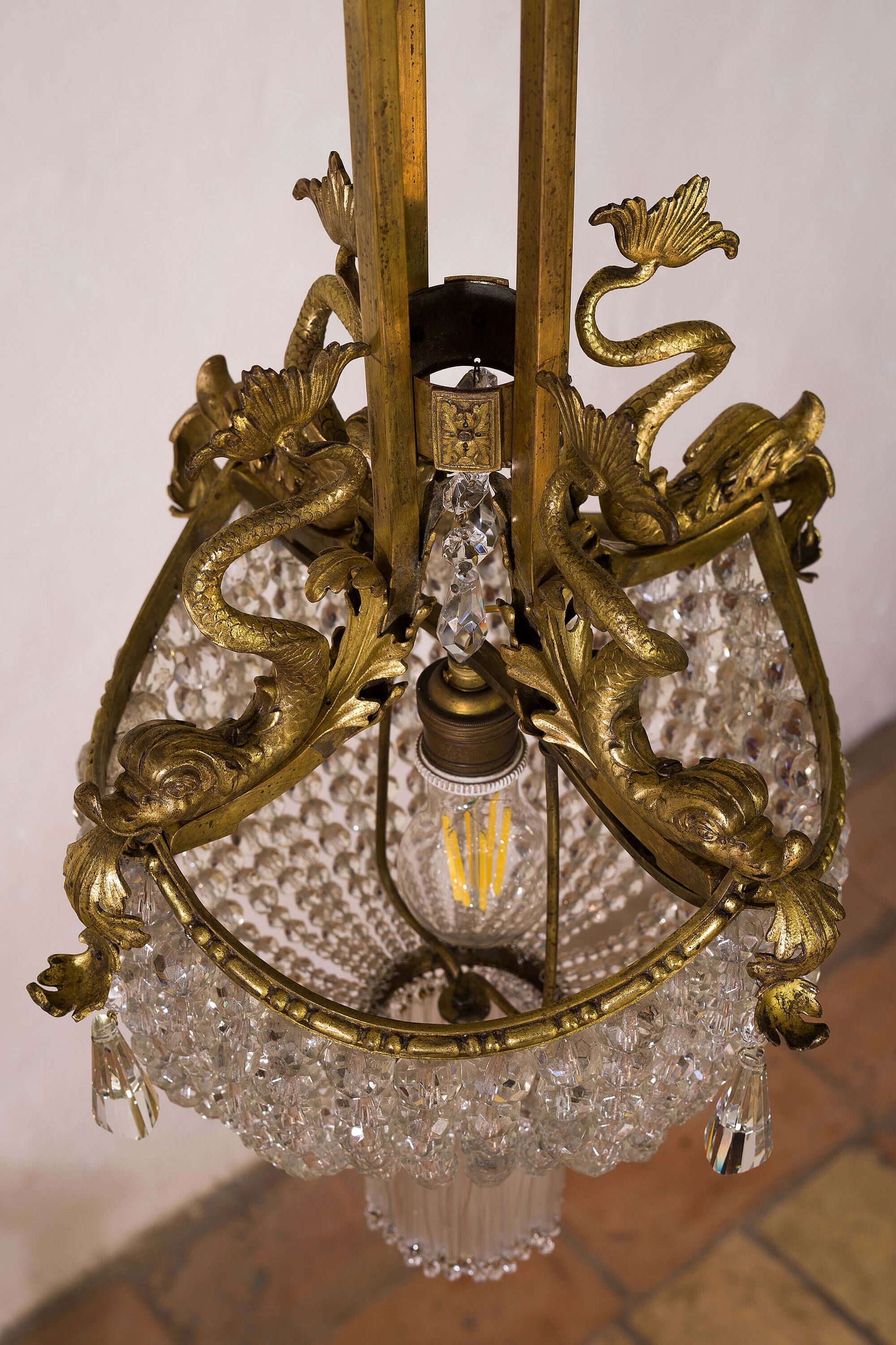 Lampadario con fusioni in ottone raffiguranti pesci mitologici. | lo Stile Italiano