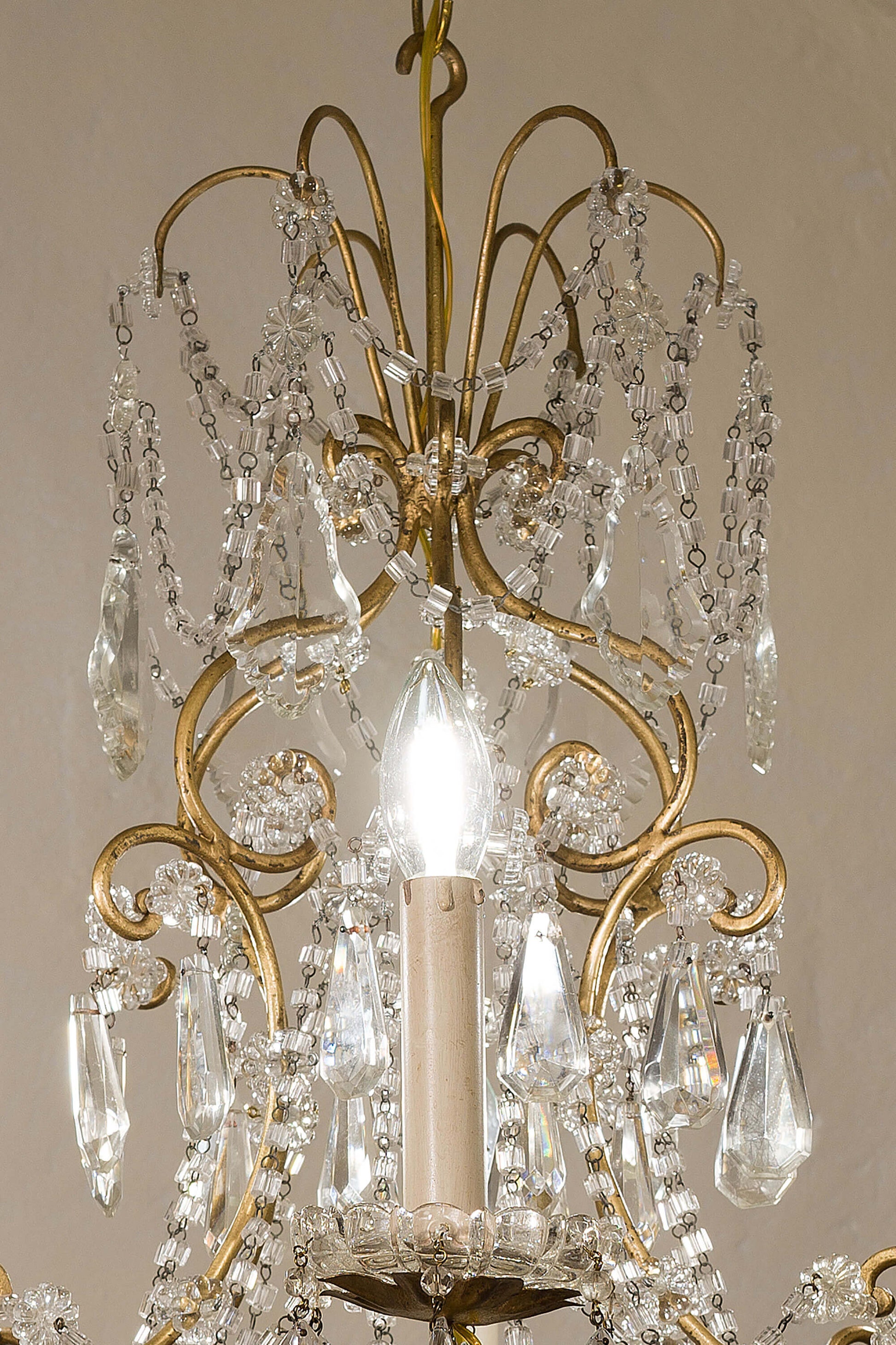 Lampadario con elegante cofanetto di cristallo al centro sormontato da un puntale di cristallo. - Lo Stile Italiano