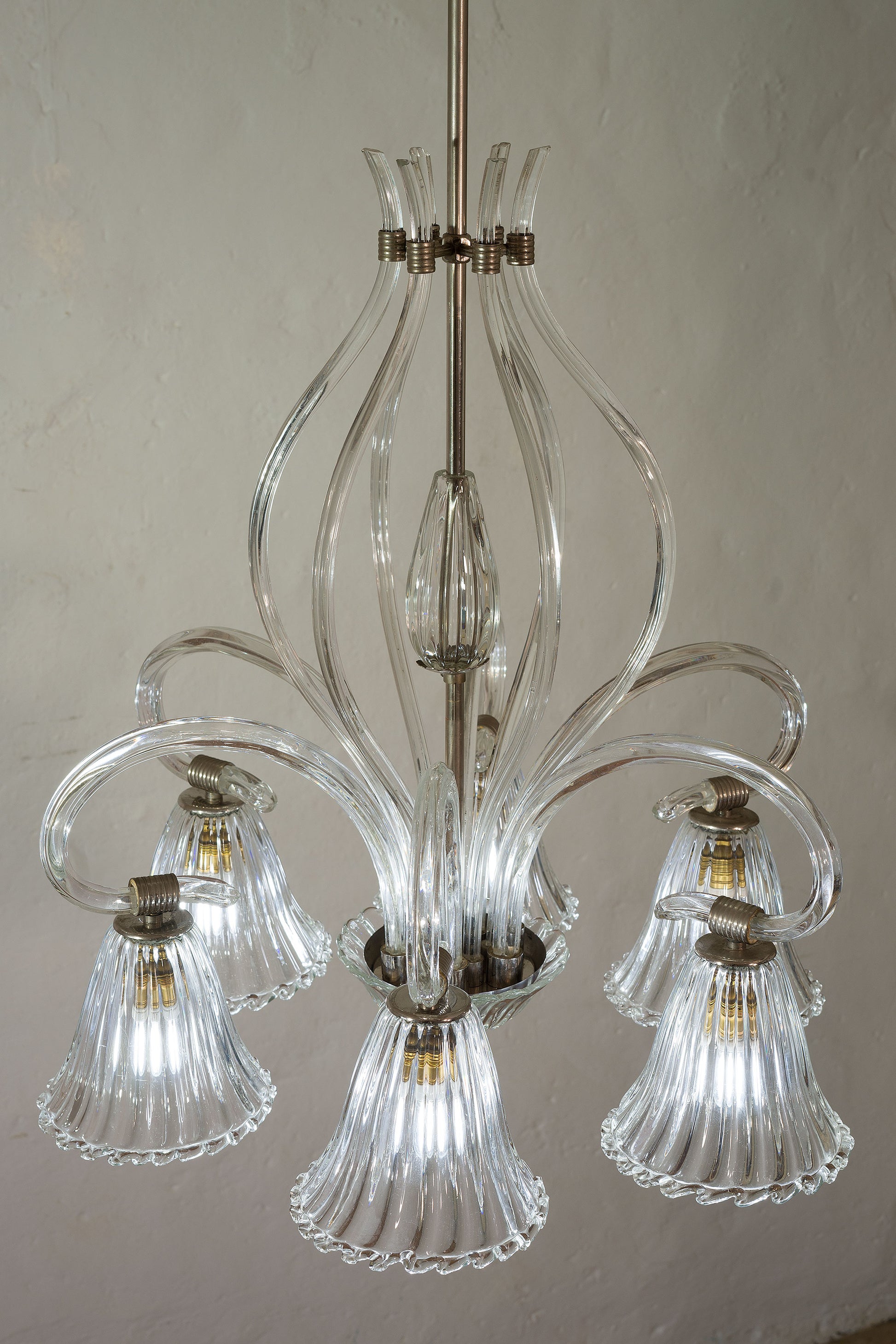 Lampadario Murano anni 40, a forma di medusa, corpo centrale in metallo cromato con un'ampolla centrale in vetro soffiato, contornata da lunghi bracci rivolti verso l'alto-Lo Stile Italiano