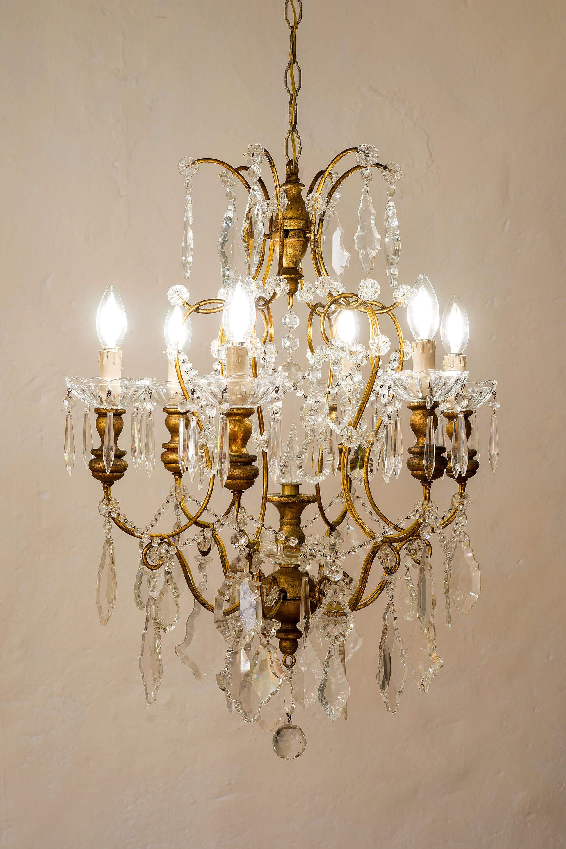 Lampadario antico in ferro battuto dorato e gocce di cristallo. | Lo Stile Italiano